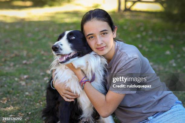 hispanic girl hugging her dog - cabeludo imagens e fotografias de stock