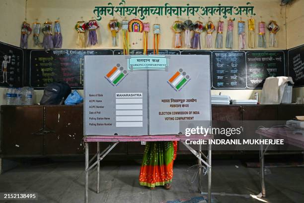 Voter casts her ballot at a polling station during the fourth phase of voting in India's general election, in Karjat of Maharashtra state on May 13,...