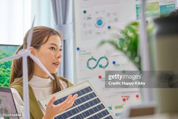 cloes up group of diversity business people having a esg meeting environment, society and governance, discussing renewable energy with wind turbine and solar panel at office - circular economy stock pictures, royalty-free photos & images