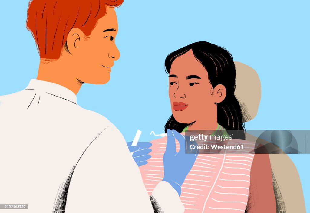 Dentist examining patient against blue background