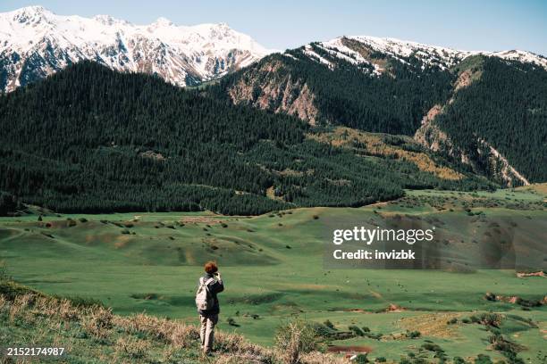 cheerful female hiker is filming mountains in spring - tien shan mountains stock pictures, royalty-free photos & images