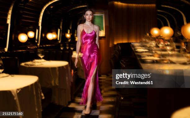 beautiful woman in glamorous gown walking at illuminated club - vestido-de-noche fotografías e imágenes de stock