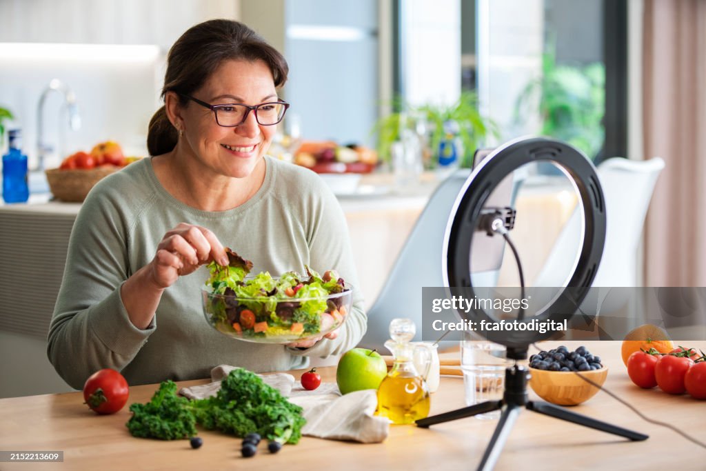 Woman blog about healthy eating, using smartphone and ring light