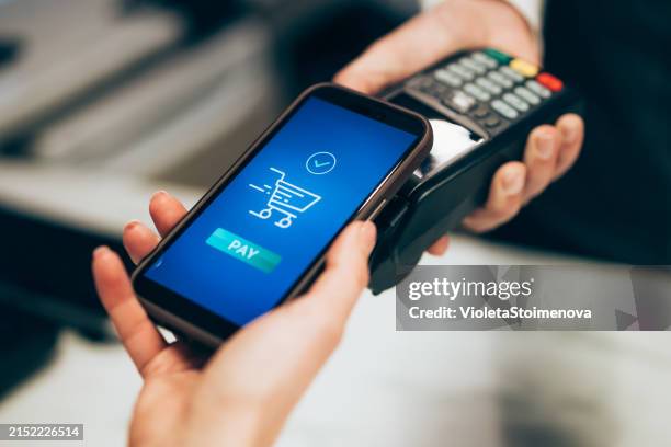 el cliente paga la factura a través de un teléfono móvil. - estación edificio de transporte fotografías e imágenes de stock