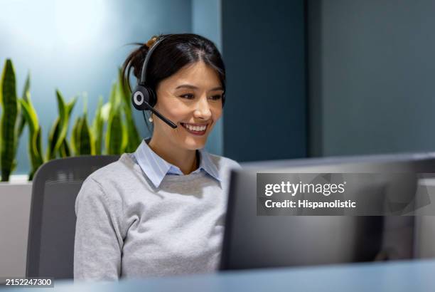 receptionist working at the office using a headset - customer retention stock pictures, royalty-free photos & images