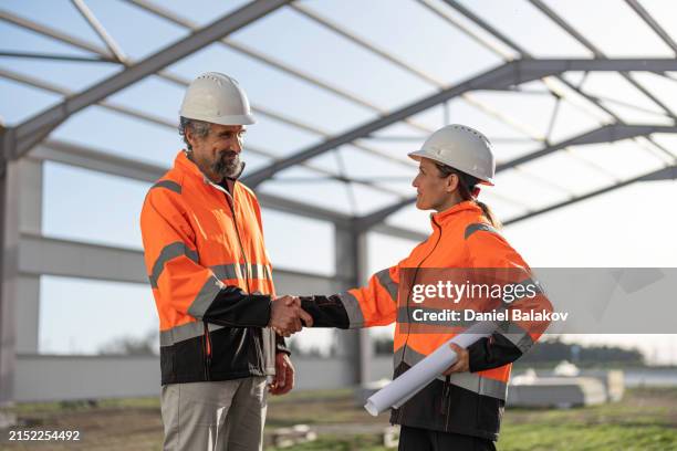 civil engineers meeting at construction site. building contractors. - bauingenieur stock-fotos und bilder