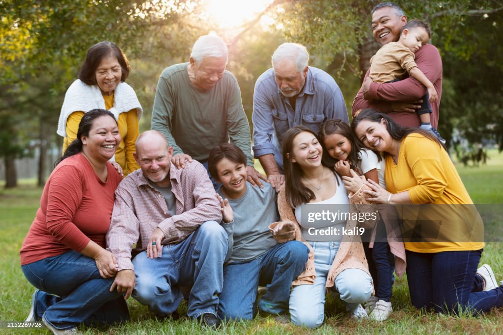 Multiracial extended family taking group photo outdoors