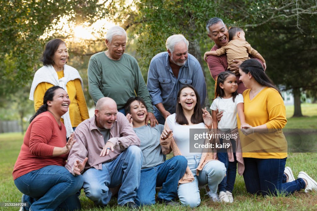 Multiracial extended family taking group photo outdoors