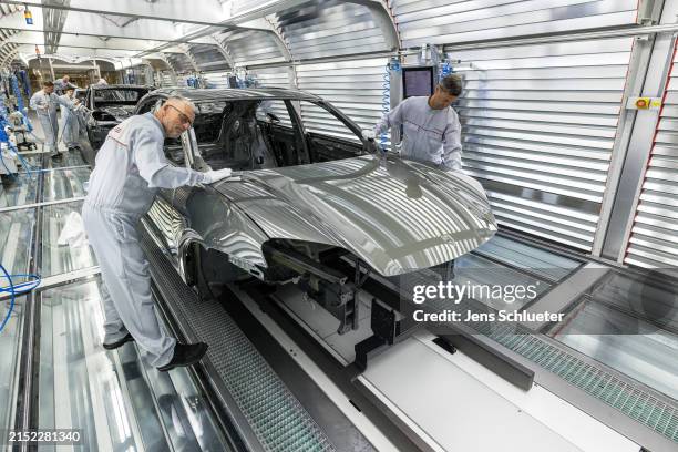 Workers assemble the new all electric Porsche Macan at the Porsche assembly plant on May 6, 2024 in Leipzig, Germany. The electric Macan is Porsche's...