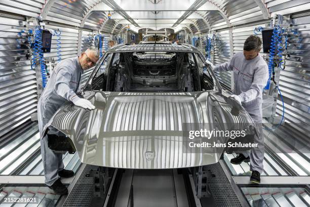 Workers assemble the new all electric Porsche Macan at the Porsche assembly plant on May 6, 2024 in Leipzig, Germany. The electric Macan is Porsche's...