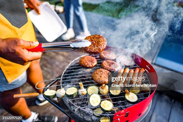 man barbecuing meat in the garden - utegrillat bildbanksfoton och bilder