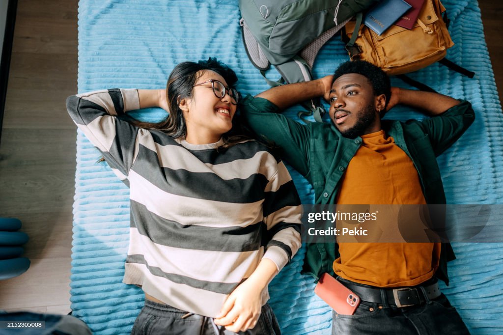 Young couple relaxing on a bed in bedroom at hotel room