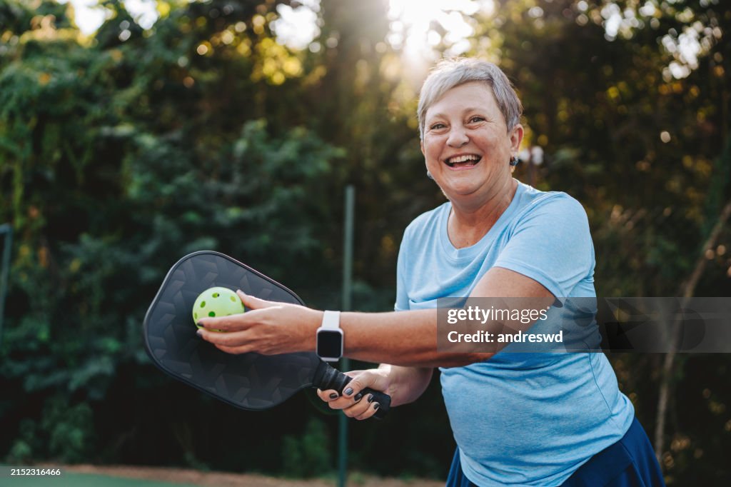 Portrait senior woman playing pickleball smiling
