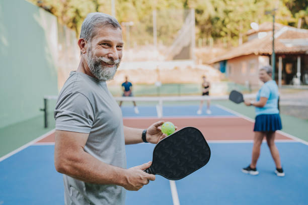 portrait elderly man looking at camera pickleball game - pickleball stock pictures, royalty-free photos & images