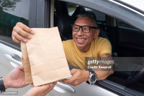 customer picking up order from restaurant - drive through stock pictures, royalty-free photos & images