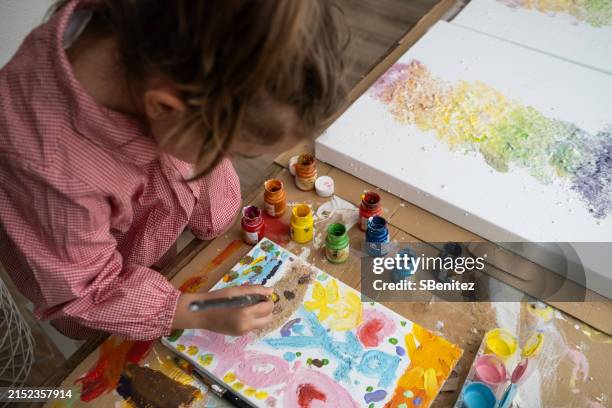 toddler girl painting with watercolor paint in artist studio - kunstatelier stockfoto's en -beelden