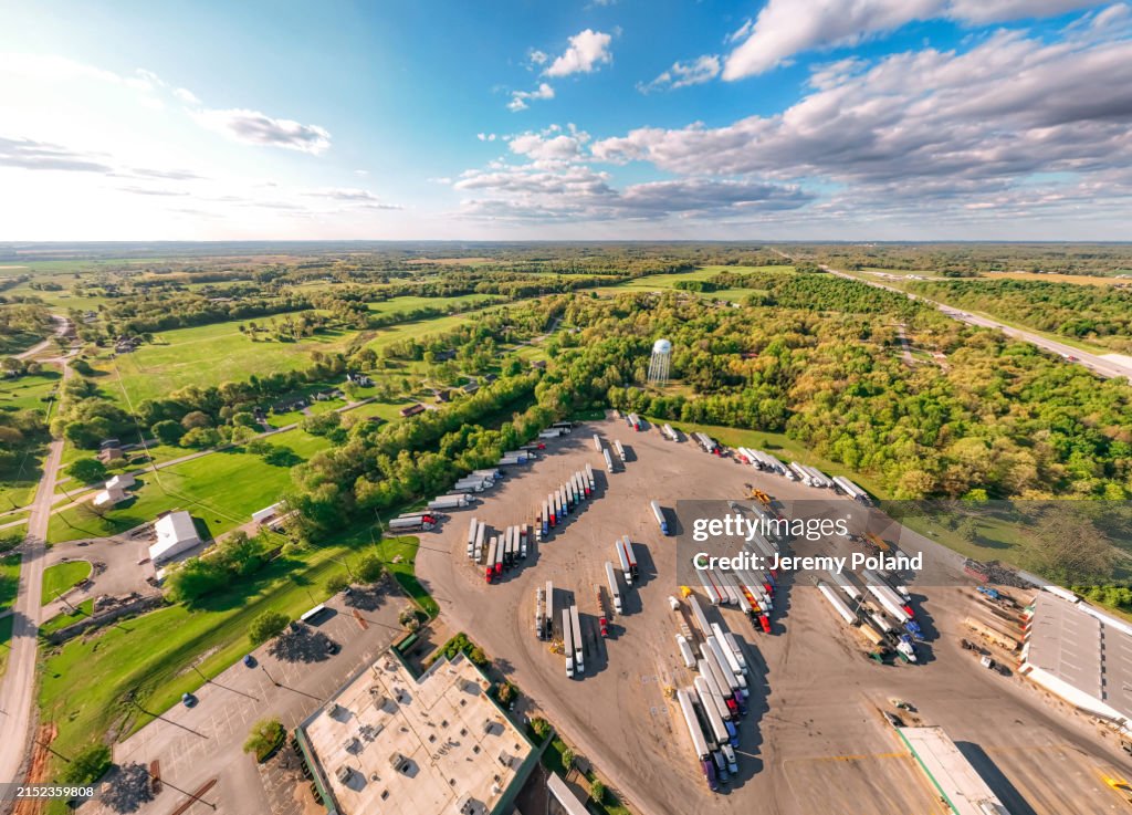 Vista de gran angular extremo de semirremolques estacionados en una parada de descanso rodeados de un bosque de naturaleza verde cerca de Bowling Green, Kentucky, EE. UU. en primavera