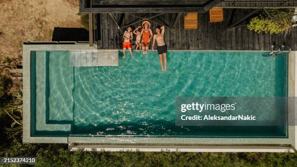 relaxing by the pool - aerial view people swimming pool stock pictures, royalty-free photos & images