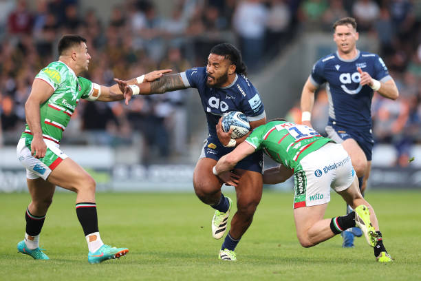Manu Tuilagi of Sale Sharks is tackled by Dan Kelly and Matt Scott of Leicester Tigers during the Gallagher Premiership Rugby match between Sale...