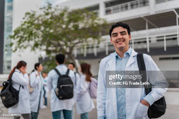portrait of young medical student man outside the university - studie-geneeskunde stockfoto's en -beelden
