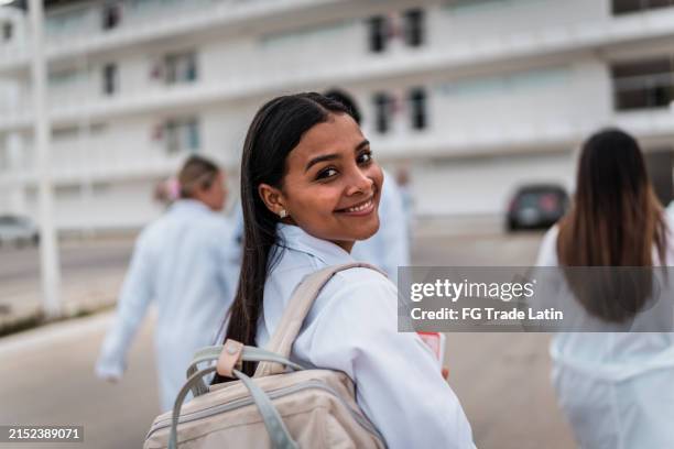 portrait of young medical student woman walking to university outdoors - medical school stock pictures, royalty-free photos & images