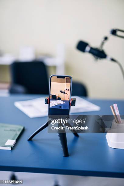 smartphone recording podcast setup on office desk - webinar phone tripod stock pictures, royalty-free photos & images