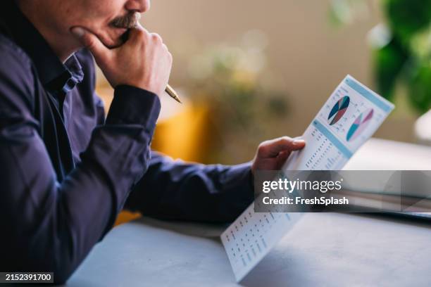 focused businessman analyzing financial data on document - knowledge graph stock pictures, royalty-free photos & images