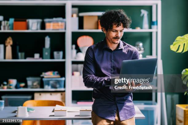 professional man using laptop in stylish office space - purple shirt stock pictures, royalty-free photos & images