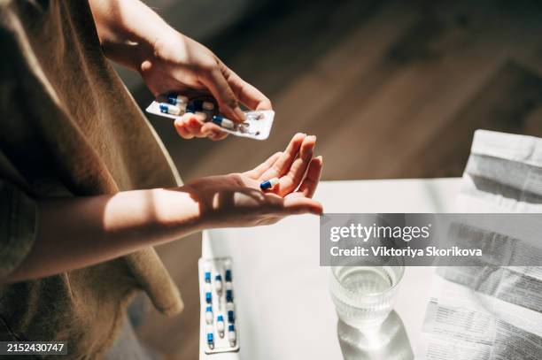 hand with pills and water glass - antibiótico imagens e fotografias de stock