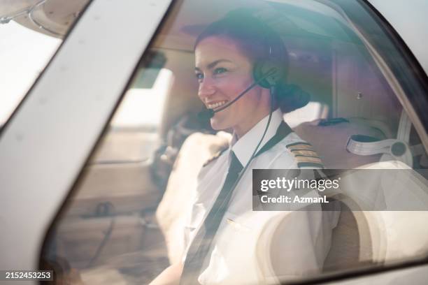 segura de sí misma piloto operando controles de aeronaves - pilotar fotografías e imágenes de stock