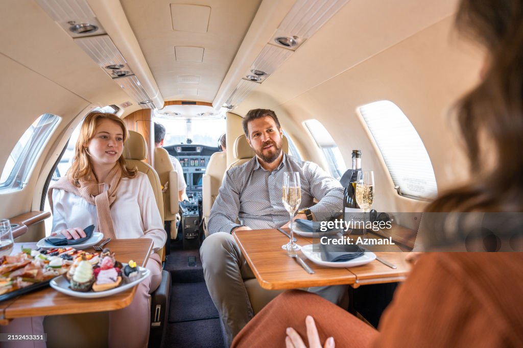 Caucasian Family Dining in Private Jet Interior