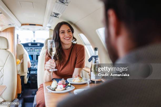 luxusfeier an bord eines privatjets mit elegantem paar - privatsphäre stock-fotos und bilder