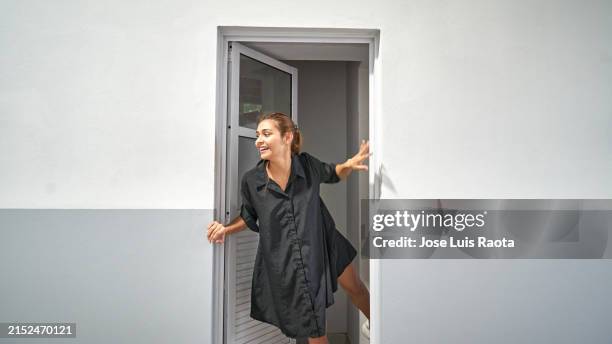 smiling businesswoman standing at doorway - abrir con llave fotografías e imágenes de stock