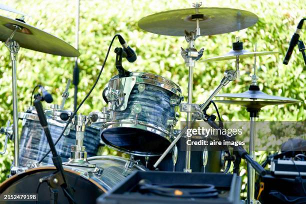 front view of empty black drums kit outside in the forest at the afternoon time - batteur photos et images de collection