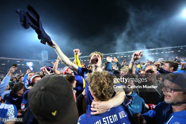 Finn Porath of Holstein Kiel celebrates on the pitch with fans after the Second Bundesliga match between Holstein Kiel and Fortuna Düsseldorf at...