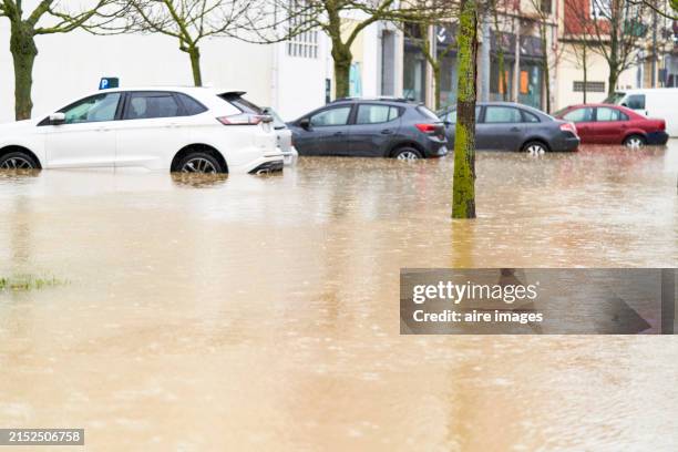 pamplona, navarra, spain - december 10, 2021: car parked on the street trapped by the flooding of the arga river in pamplona, side view - inondation photos et images de collection