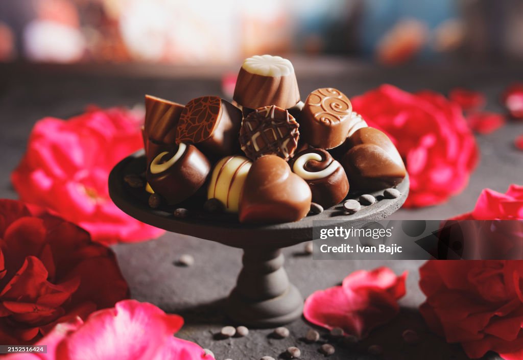 Chocolate pralines on little cake stand with red roses