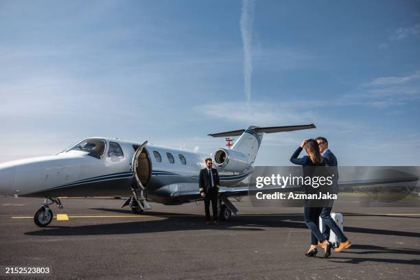 dirigenti d'azienda che camminano verso il jet privato per il viaggio - aereo privato foto e immagini stock