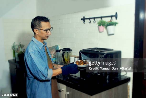 man enjoy the hobby of cooking at home. - microwave cooking stock pictures, royalty-free photos & images