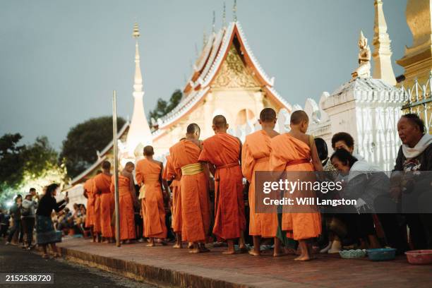 monk alms giving ceremony at dawn in luang prabang, laos - laos stock pictures, royalty-free photos & images
