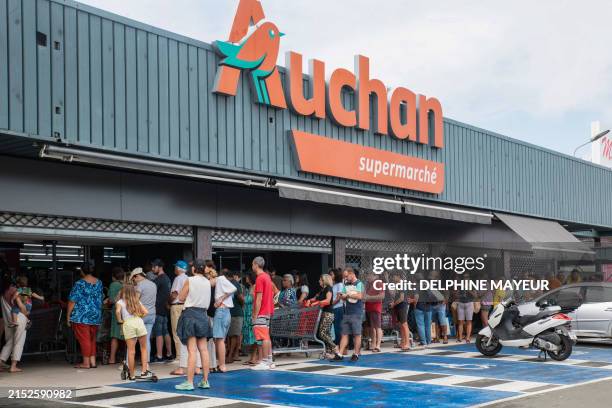 People queue outside a supermarket in Noumea on May 16 amid protests linked to a debate on a constitutional bill aimed at enlarging the electorate...
