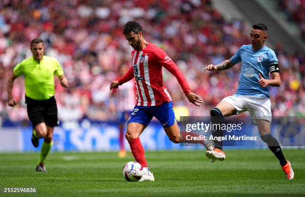 Mario Hermoso of Atletico Madrid runs with the ball whilst under pressure from Iago Aspas of Celta Vigo during the LaLiga EA Sports match between...