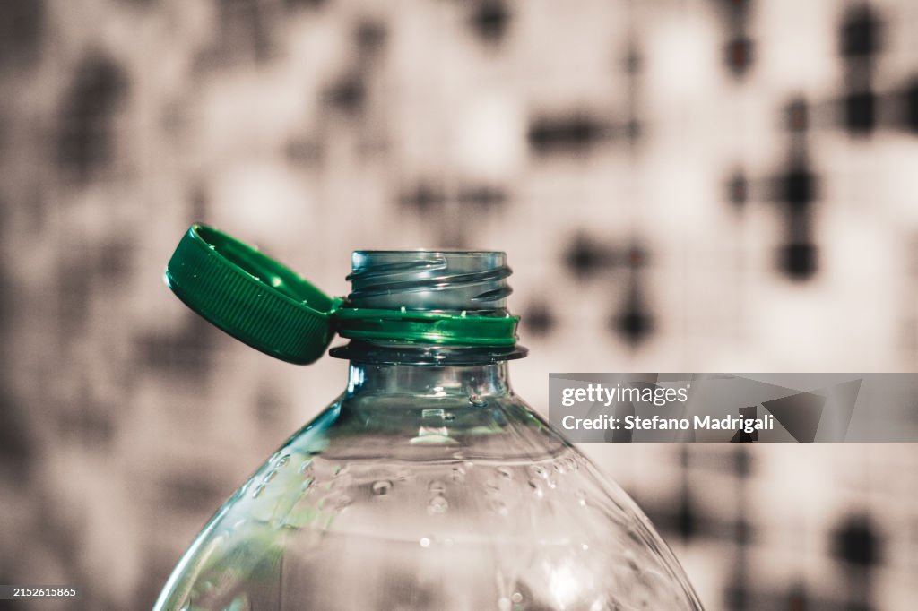Plastic bottle with cap attached to container