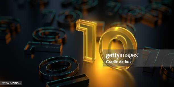 brillante número 10 que se destaca entre la multitud sobre un fondo oscuro. material de vidrio transparente amarillo brillante - 10° aniversario fotografías e imágenes de stock