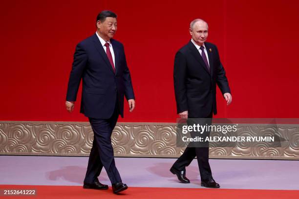 In this pool photograph distributed by the Russian state agency Sputnik, Russia's President Vladimir Putin and China's President Xi Jinping attend a...