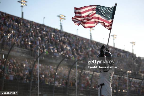 Brad Keselowski, driver of the Castrol Ford, celebrates with the American flag after winning the NASCAR Cup Series Goodyear 400 at Darlington Raceway...