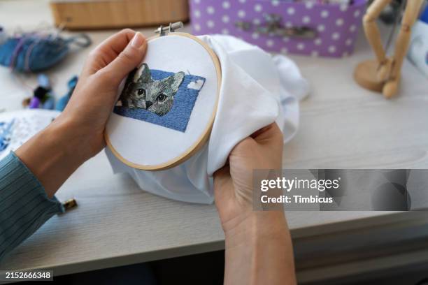 young woman's artistry: embroidering beauty stitch by stitch - cross stitch stock pictures, royalty-free photos & images