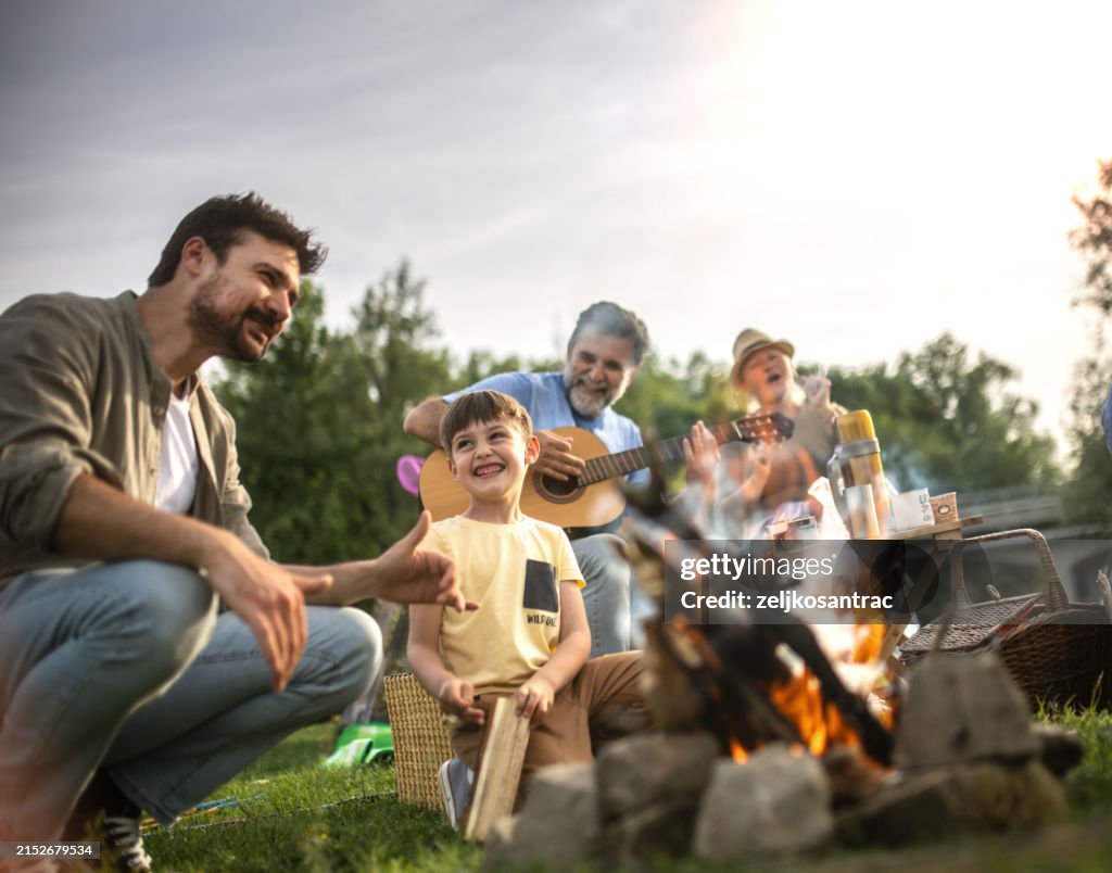 A multigenerational family is camping in nature and they make barbeque