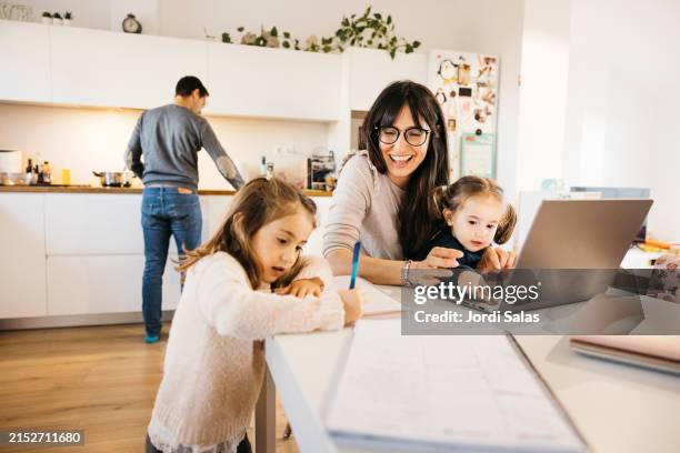 working mother doing her work at home. - homework help stock pictures, royalty-free photos & images