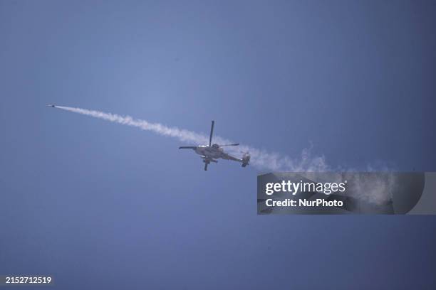 Israel's southern border with the Gaza Strip is showing an Israeli Air Force attack helicopter firing a missile while flying over the...